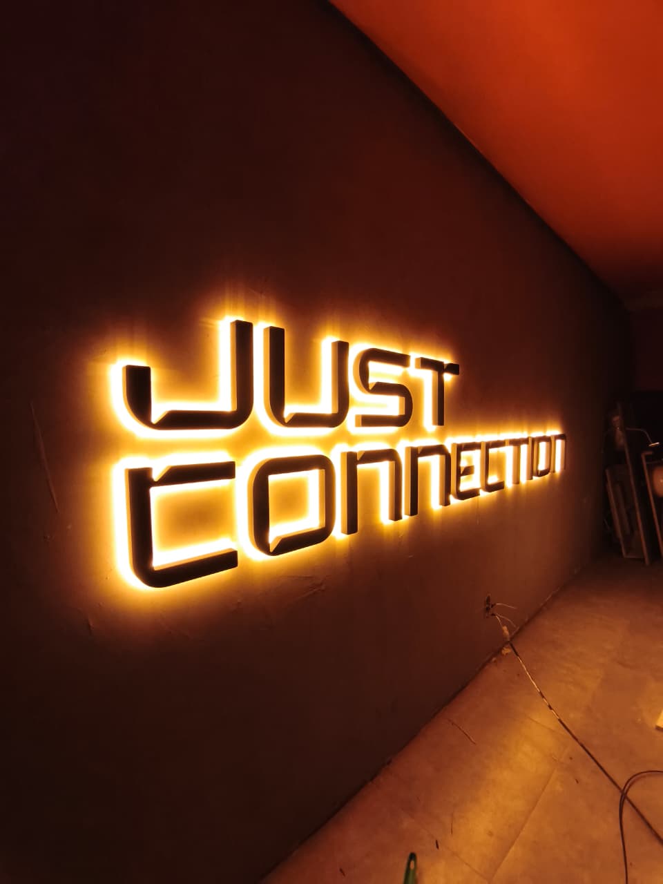 Letra caixa iluminada em backlight da Just Connection na parede